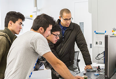 Student Success interns Derek Brigham, Jonny Nguyen and Marek Abarca work in Professor Abel Chuang’s engineering lab.