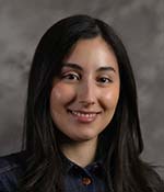 Female with brown hair wearing dark blue button up blouse